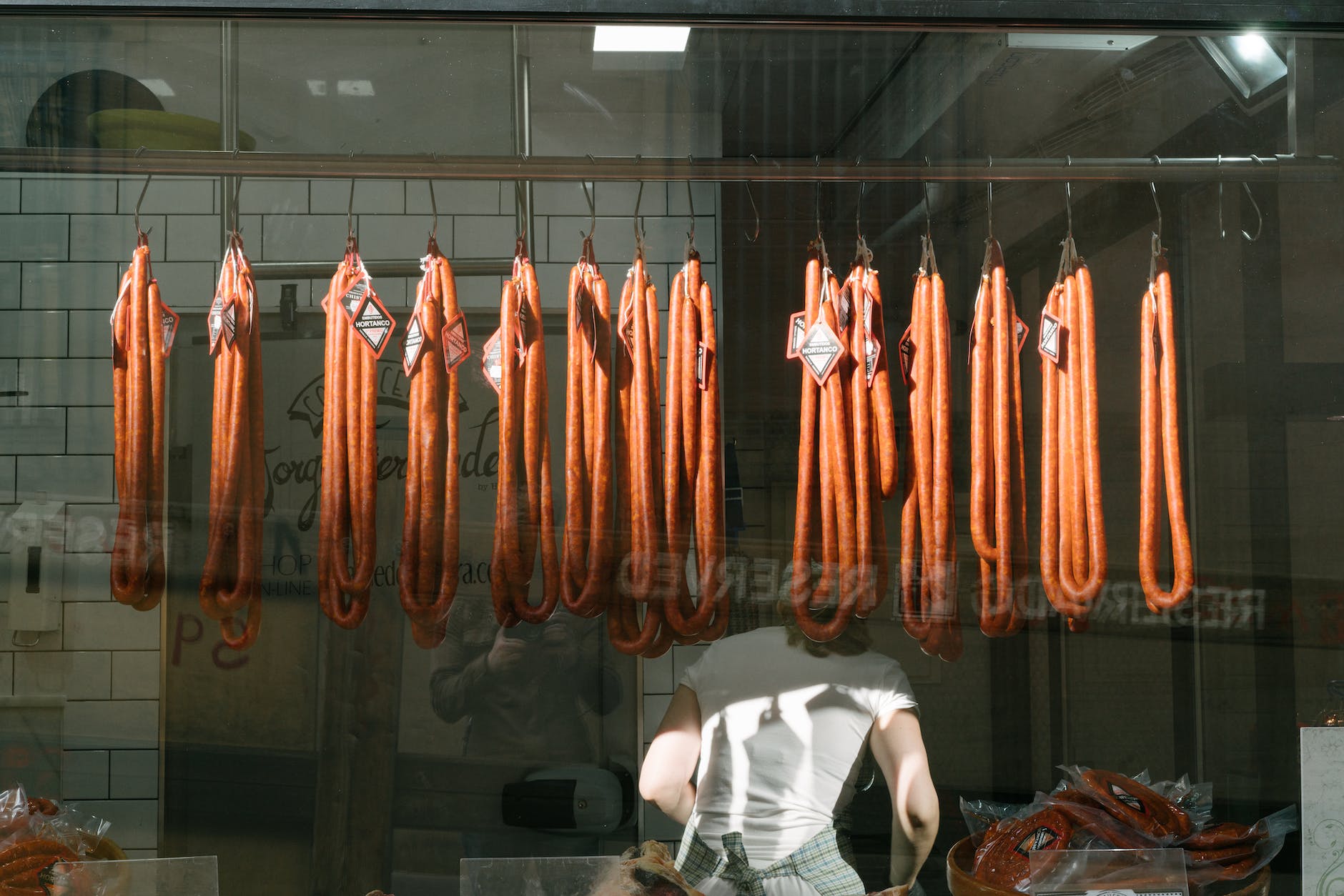 anonymous worker with long sausages at meat processing plant