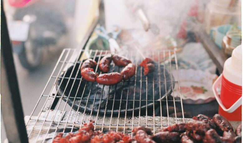 longanizas being grilled on a charcoal griller
